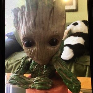 Groot planter with one hand on face